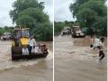 Video : नामी शक्कल !  पुराच्या पाण्यातून जाण्यासाठी ग्रामस्थ जेसीबीवर स्वार  - Marathi News | Video: Villagers ride on JCB to get through the flood waters | Latest parabhani News at Lokmat.com