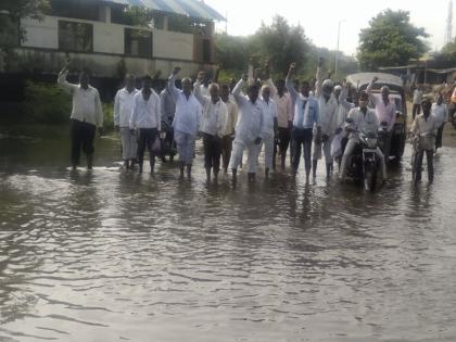 Standing in the water for the bridge at Babhulwadi in Dhule taluka | धुळे तालुक्यातील बाभुळवाडी येथेपुलासाठी पाण्यात उभे राहून आंदोलन