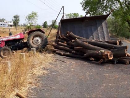 A tank filled with a rear facing the road | भर रस्त्यात उलटला लाकडे भरलेला ट्रॅक्टर