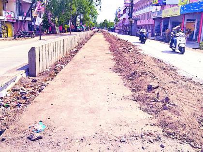 The dividing soil on the road | दुभाजकाची माती रस्त्यावर