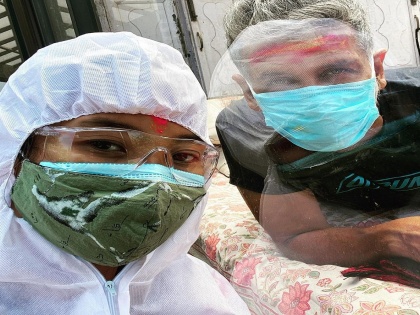 Milind Soman celebrates Holi with Ankita in PPE while being in quarantine | ‘कोरोना पॉझिटीव्ह’ मिलिंद सोमणला पीपीई किट घालून भेटायला आलेली ही व्यक्ती कोण? तुम्ही ओळखलंत?