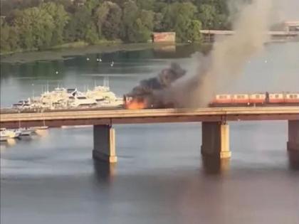 A train passing over a river bridge suddenly caught fire in Boston, america watch video | VIDEO:नदीवरील पुलावर चालत्या ट्रेनला लागली आग; जीव वाचवण्यासाठी महिलेने पाण्यात मारली उडी