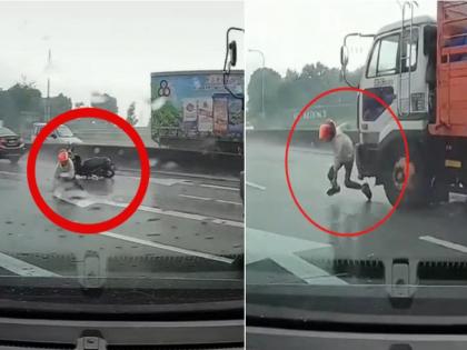 Motorcyclist Falls on Road and Escapes Being Run Over By Lorry After Quickly Jumping To Next Lane | VIDEO: दुचाकीस्वार घसरला, मागून भरधाव ट्रक आला; थरकाप उडवणारा अपघात कॅमेऱ्यात कैद