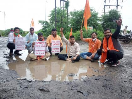 The agitation was carried out while sitting in a pothole on the road | चक्क रस्त्यावरील खड्ड्यात बसून केले आंदोलन