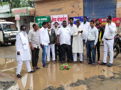 Lotus flowers left in the water in the pits on the road in Akola | अकोल्यात रस्त्यावरील खड्ड्यांमधील पाण्यामध्ये सोडली कमळाची फुले