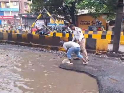 Potholes filled by traffic police in Bhiwandi; Municipal administration's neglect of potholes | भिवंडीत वाहतूक पोलिसांनी बुजवले खड्डे; मनपा प्रशासनाचे खड्ड्यांकडे दुर्लक्ष