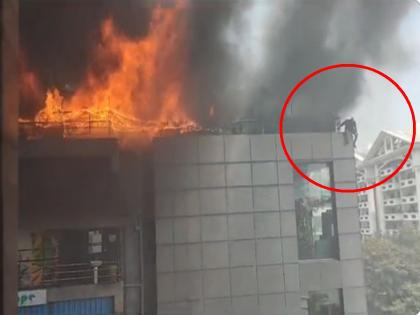 Fire breaks out at building in Bangalore, youth jumps from roof to save life | बेंगलोरमधील इमारतीला भीषण आग, युवकानं छतावरून मारली उडी; Video पाहून अंगावर शहारा येईल