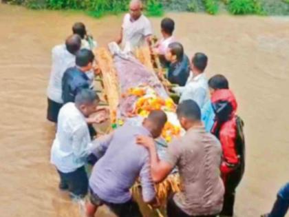 A funeral procession through the waters of the Dahanoot flood There is no road even to reach the graveyard | डहाणूत पुराच्या पाण्यातून अंत्ययात्रा; स्मशानभूमीत पोहोचायलाही रस्ता नाही