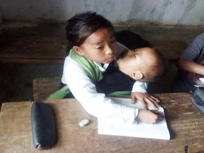 Emotional, trending Story: Tears well up in the eyes of netizens; A 10 year old Manipuri girl is sitting at school, studying with her younger brother on her lap | Emotional Story: अवघ्या नेटकऱ्यांच्या डोळ्यांत अश्रू तरळले; १० वर्षांची विद्यार्थिनी लहान भावाला मांडीवर घेऊन शाळेत बसतेय