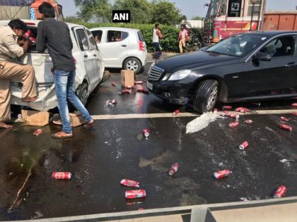 A car filled with beer, in a liquor-laden street in Gujarat; Crowd of people to pick up bottles | दारूबंदी असणाऱ्या गुजरातमधील रस्त्यावर उलटली बीअरने भरलेली कार; बाटल्या उचलण्यासाठी लोकांची गर्दी