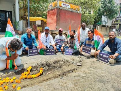 Youth Congress workers put garlands on pits shouting slogans like 'Ek Khoka, Nagarkarana Dhoka' | ‘एक खोका, नगरकरांना धोका’ अशा घोषणा देत युवक काँग्रेस कार्यकर्त्यांनी खड्ड्यांना घातले हार