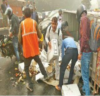 The truck overturned on the road and people ran away with liquor bottles | रस्त्यावर ट्रक पलटला आणि लोक दारुच्या बाटल्या घेऊन पळाले