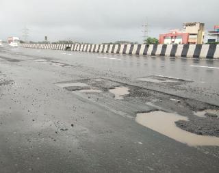 Pillar on the bridge of Mumbai-Pune Expressway | मुंबई-पुणे एक्सप्रेस वेच्या पुलावर खड्डयांची चाळण