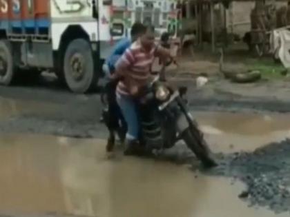 two people riding bullet bike fall in hole on road, holes in the rood due to monsoon rain | रस्त्यावर चालवत होते बाईक, मग झाले असे की, लोक पोट धरुन हसू लागले...