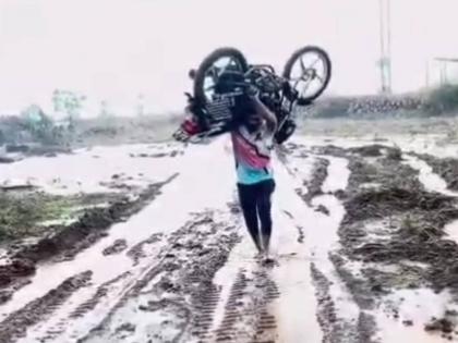 Video of Bahubali in Satara goes viral, bike pulled out of mud in field with shoulder | साताऱ्यातील बाहुबलीचा व्हिडीओ व्हायरल, शेतातील चिखलातून दुचाकी खांद्यावर घेऊन बाहेर काढली