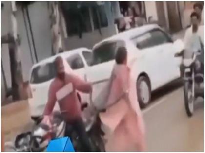 VIDEO : Man catches snake bare hands while on bike woman sitting behind him runs away | VIDEO : रस्त्यावरून जात होता साप, बाइक थांबवून व्यक्तीने पकडताच मागे बसलेली महिला पळाली....