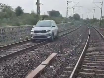 Shocking! Woman drives car on railway tracks to make a reel, ends up... | Video: धक्कादायक! रील बनवण्यासाठी महिलेने चक्क रेल्वे रुळांवरून चालवली कार, अखेरीस... Shocking! Woman drives car on railway tracks to make a reel, ends up... | Video: धक्कादायक! रील बनवण्यासाठी महिलेने चक्क रेल्वे रुळांवरून चालवली कार, अखेरीस...
