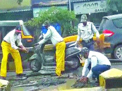 Road pits filled with traffic police | होय हे खरंय ! वाहतूक पोलिसांनी भरले रस्त्यावरील खड्डे