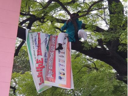 'Develop the ward or bury me'; Youth's agitation by climbing a tree near the Municipal Corporation | 'वॉर्डाचा विकास करा किंवा माझे अंतिम संस्कार करा'; महापालिकेजवळील झाडावर चढून तरुणाचे आंदोलन