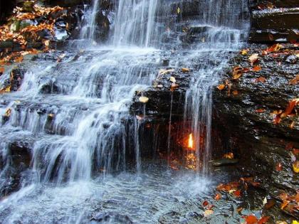 Eternal Flame Falls wonder in world mystery unsolved by scientists | धबधब्याच्या मधोमध पाण्यात तेवत असते ज्योत, वैज्ञानिक अजूनही शोधू शकले नाही यामागचं सत्य