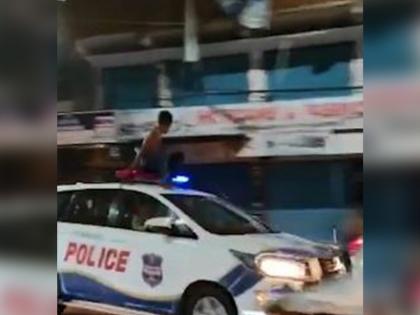 Shirtless man climbs atop moving police car in hyderabad watch viral video | Video : पठ्ठ्या शर्टलेस होऊन चालत्या पोलिसांच्या गाडीवर चढला, खतरनाक स्टंटचा व्हिडिओ झाला व्हायरल