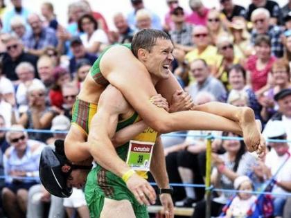 lithuanian couple win world wife carrying championship | पत्नीला पाठीवर उचलून 'तो' धावला अन् वर्ल्ड चॅम्पियन ठरला!