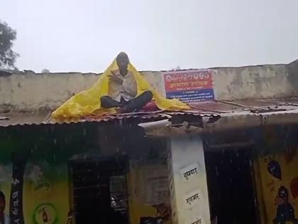 Deplorable state of ZP school; A unique agitation of a Gram Panchayat member sitting on a tin patras roof top in full rain | झेडपी शाळेची दयनीय अवस्था; तुटक्या पत्रावर बसून ग्रामपंचायत सदस्याचे अनोखे आंदोलन