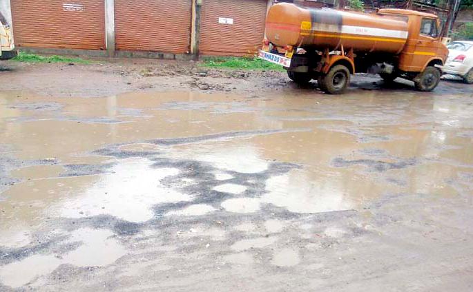 Sidewalk | पाण्यामुळे रस्त्याची झाली चाळणी