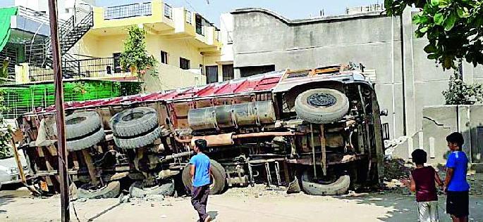 The truck turned turtle on the fence | दहाचाकी ट्रक उलटला कुंपणभिंतीवर The truck turned turtle on the fence | दहाचाकी ट्रक उलटला कुंपणभिंतीवर
