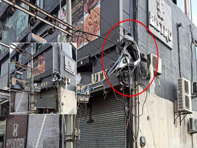 A video of a scooty stuck in a 15 feet high light wire due to a storm in Jammu is going viral | ऐकावं ते नवलच! जोरदार वादळात स्कूटी उडाली; १५ फूट उंचीवर तारांमध्ये जाऊन अडकली A video of a scooty stuck in a 15 feet high light wire due to a storm in Jammu is going viral | ऐकावं ते नवलच! जोरदार वादळात स्कूटी उडाली; १५ फूट उंचीवर तारांमध्ये जाऊन अडकली