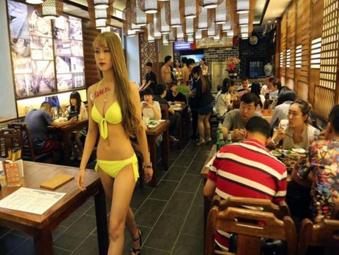 China restaurant female waiters serve food in bikni | बाबो! ग्राहकांना आकर्षित करण्याचा फंडा, इथे बिकीनी घालून जेवण वाढतात तरूणी!