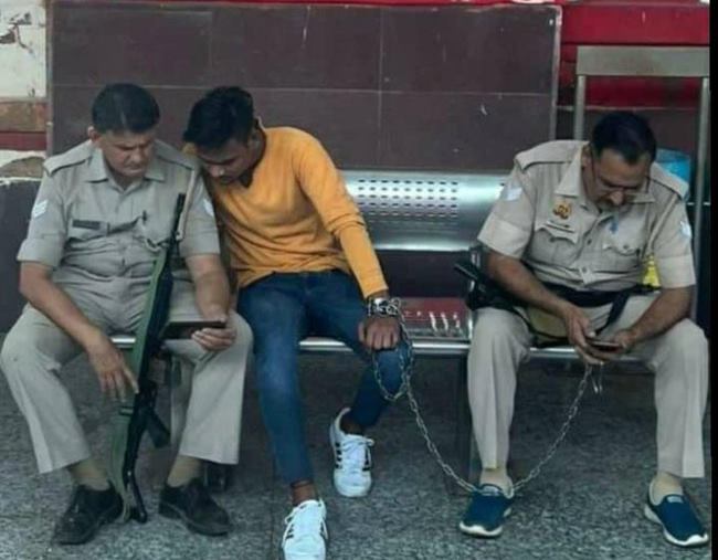 I became 'obsessed' with mobile; Handcuffs and police phones in the hands of the prisoner, photo viral on social media | मला 'वेड' लागले मोबाईलचे; कैद्याच्या हाती बेड्या अन् पोलिसांच्या फोन I became 'obsessed' with mobile; Handcuffs and police phones in the hands of the prisoner, photo viral on social media | मला 'वेड' लागले मोबाईलचे; कैद्याच्या हाती बेड्या अन् पोलिसांच्या फोन