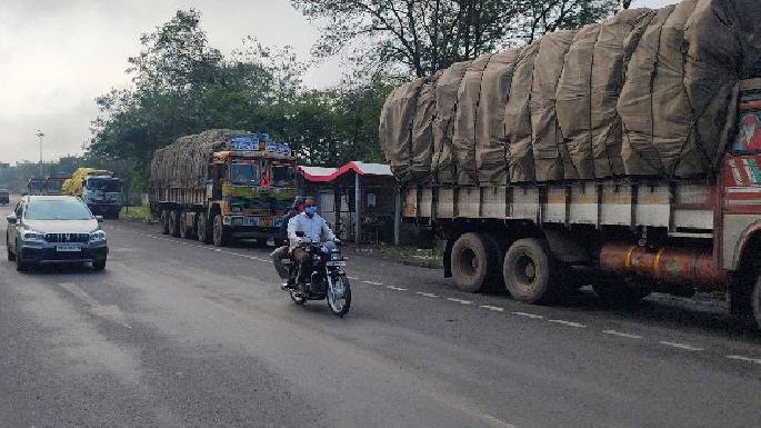 parked truck covers the bus stop area passenger gets problem to seat | ट्रकांनी गिळंकृत केला बसथांबा, प्रवासी वाहन थांबत नसल्याने नागरिक हैराण parked truck covers the bus stop area passenger gets problem to seat | ट्रकांनी गिळंकृत केला बसथांबा, प्रवासी वाहन थांबत नसल्याने नागरिक हैराण