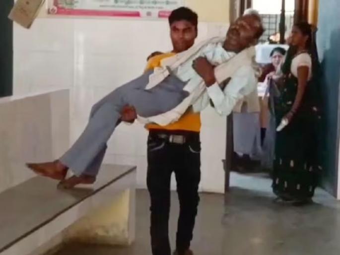 son is carrying his father in his lap in government hospital to get him treated | ना स्ट्रेचर मिळालं ना डॉक्टर...; आजारी वडिलांना उचलून घेऊन रुग्णालयात फिरत राहिला मुलगा son is carrying his father in his lap in government hospital to get him treated | ना स्ट्रेचर मिळालं ना डॉक्टर...; आजारी वडिलांना उचलून घेऊन रुग्णालयात फिरत राहिला मुलगा