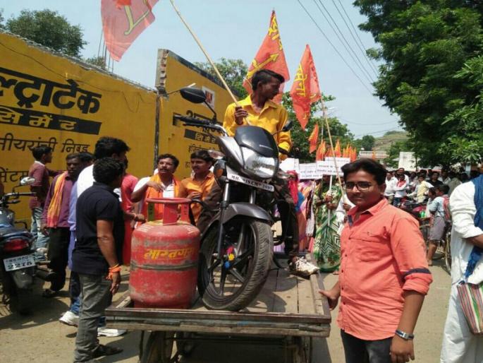 Shiv Sena's movement by keeping a two wheeler on cooking and carpeting | सरपणावर स्वयंपाक व ढकलगाडीवर दुचाकी ठेऊन शिवसेनेचे आंदोलन Shiv Sena's movement by keeping a two wheeler on cooking and carpeting | सरपणावर स्वयंपाक व ढकलगाडीवर दुचाकी ठेऊन शिवसेनेचे आंदोलन
