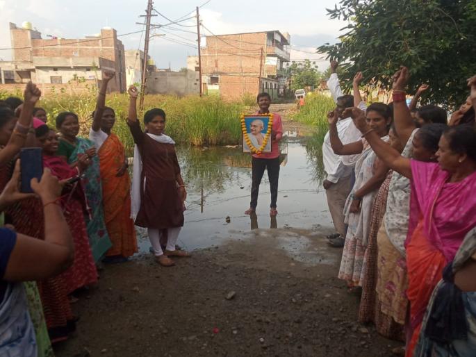 protest with mahatma gandhi photo for the road at kalmana | कळमना येथे रस्त्यासाठी महात्मा गांधींच्या प्रतिमेसह निदर्शने protest with mahatma gandhi photo for the road at kalmana | कळमना येथे रस्त्यासाठी महात्मा गांधींच्या प्रतिमेसह निदर्शने