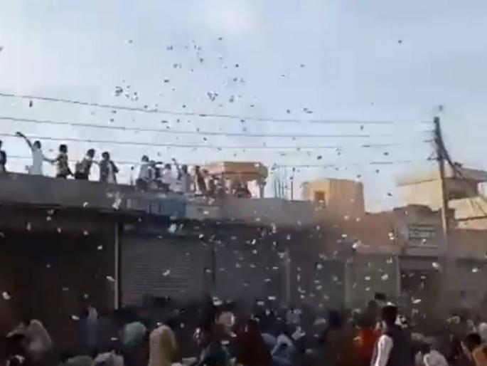 pakistan notes showered at wedding from helicopter in mandi bahauddin | पाकिस्तानात हेलिकॉप्टरमधून 'नोटांचा पाऊस', पैसा जमा करण्यासाठी उडाली झुंबड;  Video व्हायरल pakistan notes showered at wedding from helicopter in mandi bahauddin | पाकिस्तानात हेलिकॉप्टरमधून 'नोटांचा पाऊस', पैसा जमा करण्यासाठी उडाली झुंबड;  Video व्हायरल