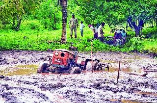 The tractor lying deep in the saddle of farming while doing farming. | गिरणारे येथे शेतीची मशागत करताना गाळात खोलवर रुतलेला ट्रॅक्टर.