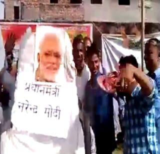 Bharatiya Sabha minister shot dead on Modi's photo, said the robbers | भरसभेत मंत्र्यामुळे मोदींच्या फोटोवर मारल्या चपला, म्हणाले डाकू Bharatiya Sabha minister shot dead on Modi's photo, said the robbers | भरसभेत मंत्र्यामुळे मोदींच्या फोटोवर मारल्या चपला, म्हणाले डाकू