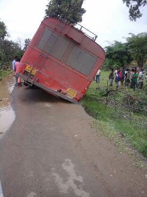 Busy bus passes down the road | रस्ता खचून बस कलंडली Busy bus passes down the road | रस्ता खचून बस कलंडली