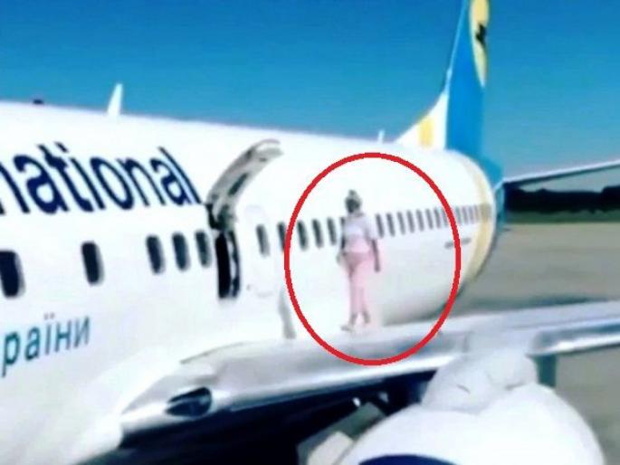 Video : Woman walks on airplane wing after complaining about feeling too hot | खतरनाक कारनामा! विमानात उकडायला लागलं म्हणून महिला इमरजन्सी दरवाजा उघडून पंखावर फिरू लागली! Video : Woman walks on airplane wing after complaining about feeling too hot | खतरनाक कारनामा! विमानात उकडायला लागलं म्हणून महिला इमरजन्सी दरवाजा उघडून पंखावर फिरू लागली!