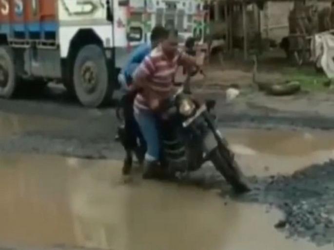 two people riding bullet bike fall in hole on road, holes in the rood due to monsoon rain | रस्त्यावर चालवत होते बाईक, मग झाले असे की, लोक पोट धरुन हसू लागले... two people riding bullet bike fall in hole on road, holes in the rood due to monsoon rain | रस्त्यावर चालवत होते बाईक, मग झाले असे की, लोक पोट धरुन हसू लागले...