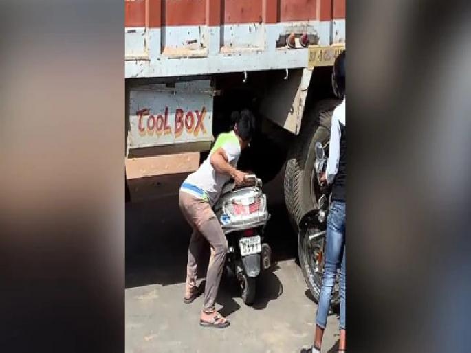A young man stuck in a traffic jam; Got Out Vehicle Under The Truck | ट्रॅफिक जाममधून सुटका करण्यासाठी बाईकस्वाराची शक्कल; २ कोटींपेक्षा जास्त वेळा पाहिला गेला व्हिडीओ A young man stuck in a traffic jam; Got Out Vehicle Under The Truck | ट्रॅफिक जाममधून सुटका करण्यासाठी बाईकस्वाराची शक्कल; २ कोटींपेक्षा जास्त वेळा पाहिला गेला व्हिडीओ