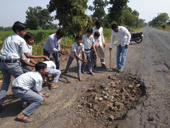 Teachers, students take initiative to level potholes on the highway | महामार्गावरील खड्डे बुजविण्यासाठी शिक्षक, विद्यार्थी रस्त्यावर Teachers, students take initiative to level potholes on the highway | महामार्गावरील खड्डे बुजविण्यासाठी शिक्षक, विद्यार्थी रस्त्यावर