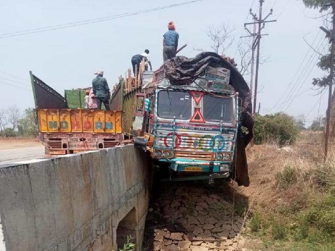 A truck loaded with wood overhangs the bridge, luckily averting a major accident | लाकडाने भरलेला ट्रक पुलावर आदळून लटकला, सुदैवाने मोठी दुर्घटना टळली A truck loaded with wood overhangs the bridge, luckily averting a major accident | लाकडाने भरलेला ट्रक पुलावर आदळून लटकला, सुदैवाने मोठी दुर्घटना टळली