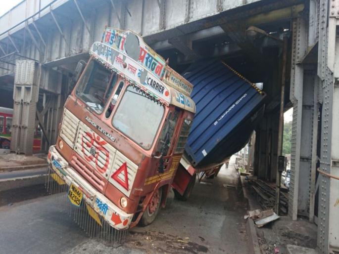 Mumbai: A container truck met with an accident at King Circle railway bridge | मुंबई : किंग्स सर्कल रेल्वे पुलाखाली कंटेनर अडकल्यानं वाहतुकीचा खोळंबा  Mumbai: A container truck met with an accident at King Circle railway bridge | मुंबई : किंग्स सर्कल रेल्वे पुलाखाली कंटेनर अडकल्यानं वाहतुकीचा खोळंबा