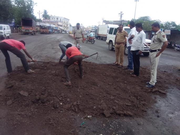 police fills pothole on the main road in Vaipur | वैजापुरात अपघात टाळण्यासाठी पोलिसांनीच बुजवले मुख्य रस्त्यावरील खड्डे police fills pothole on the main road in Vaipur | वैजापुरात अपघात टाळण्यासाठी पोलिसांनीच बुजवले मुख्य रस्त्यावरील खड्डे