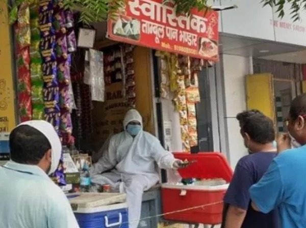 CoronaVirus Marathi News meet paan seller wearing ppe kit selling paan banaras | CoronaVirus News : कोरोनाचा धसका! पीपीई किट परिधान करून पानवाला चालवतोय टपरी CoronaVirus Marathi News meet paan seller wearing ppe kit selling paan banaras | CoronaVirus News : कोरोनाचा धसका! पीपीई किट परिधान करून पानवाला चालवतोय टपरी