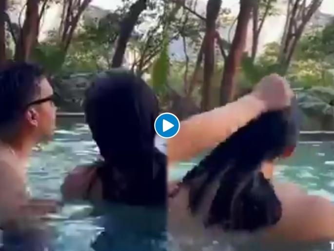 Viral Video : Husband taking with stranger wife pulled hair in anger and gets amazing shock see viral video | बोंबला! स्विमिंग पूलमध्ये अनोखळी मुलीशी बोलायला गेला; पत्नीनं पाहताचं केलं असं काही, पाहा व्हिडीओ Viral Video : Husband taking with stranger wife pulled hair in anger and gets amazing shock see viral video | बोंबला! स्विमिंग पूलमध्ये अनोखळी मुलीशी बोलायला गेला; पत्नीनं पाहताचं केलं असं काही, पाहा व्हिडीओ