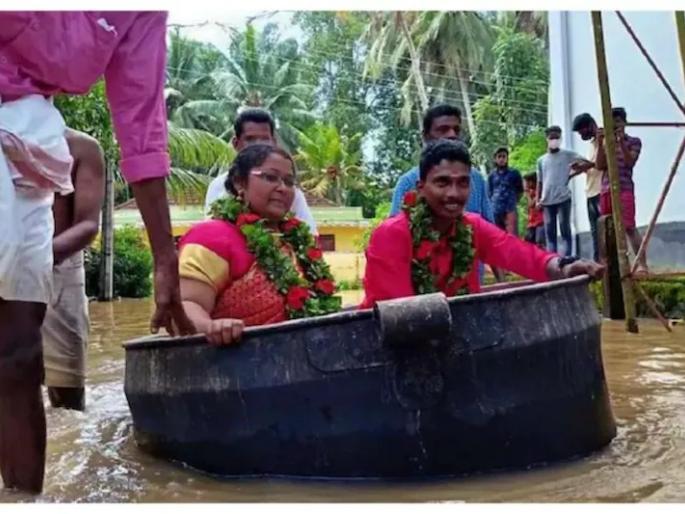 kerala rains flood bride and groom use cauldron to reach wedding venue video viral | लग्नासाठी काय पण! केरळच्या मुसळधार पावसात जोडपं अडकलं; टोपात बसून मंडपात पोहचलं kerala rains flood bride and groom use cauldron to reach wedding venue video viral | लग्नासाठी काय पण! केरळच्या मुसळधार पावसात जोडपं अडकलं; टोपात बसून मंडपात पोहचलं